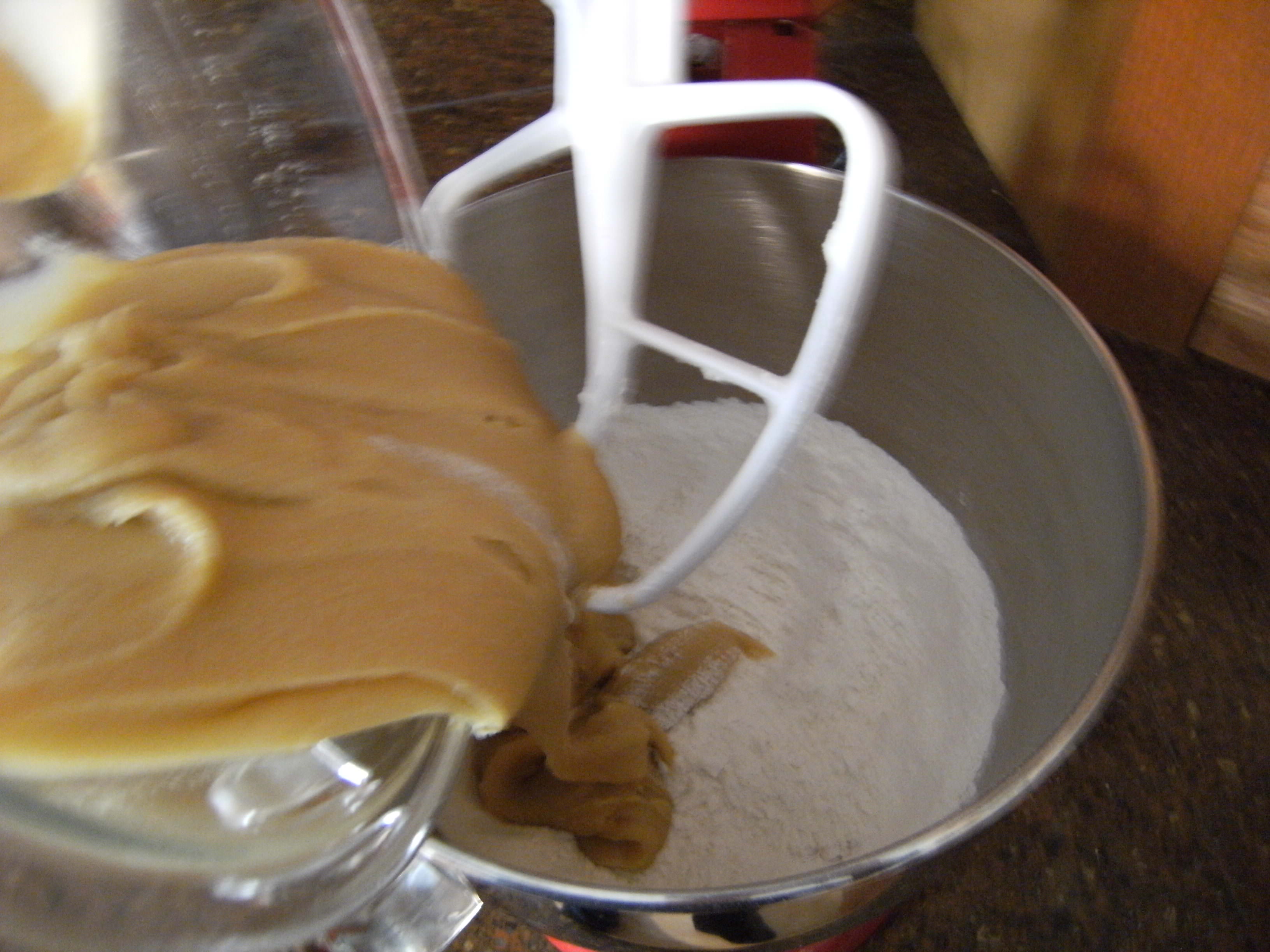 pouring wet ingredients into dry ingredients for a batch of my favorite chocolate chip cookies