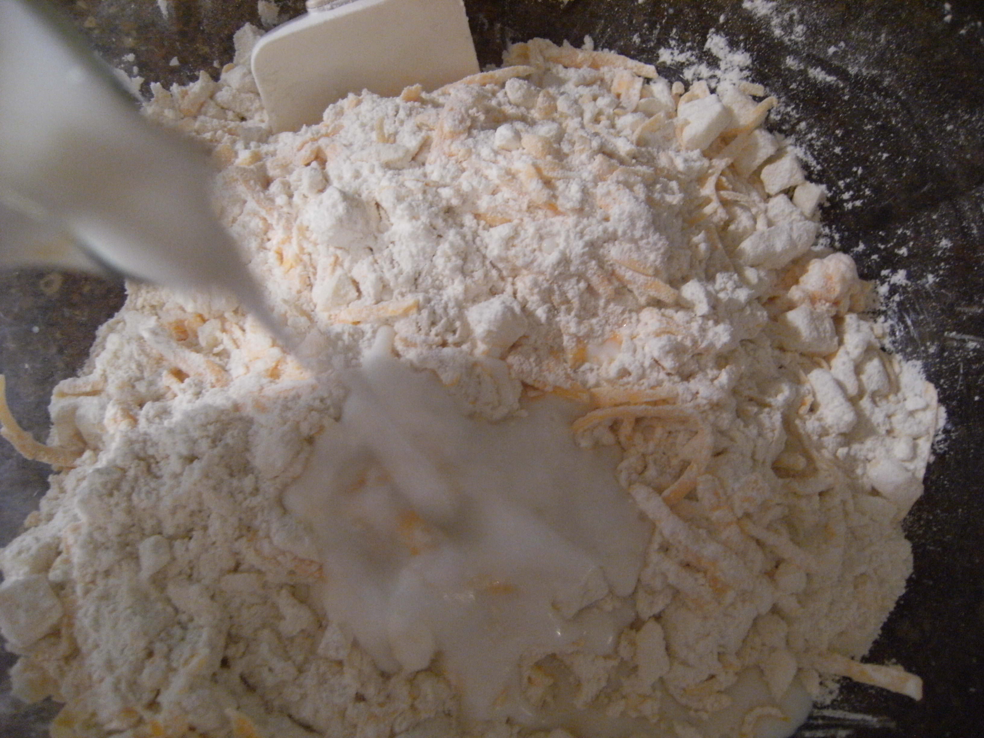 combining wet ingredients with dry ingredients to make scones