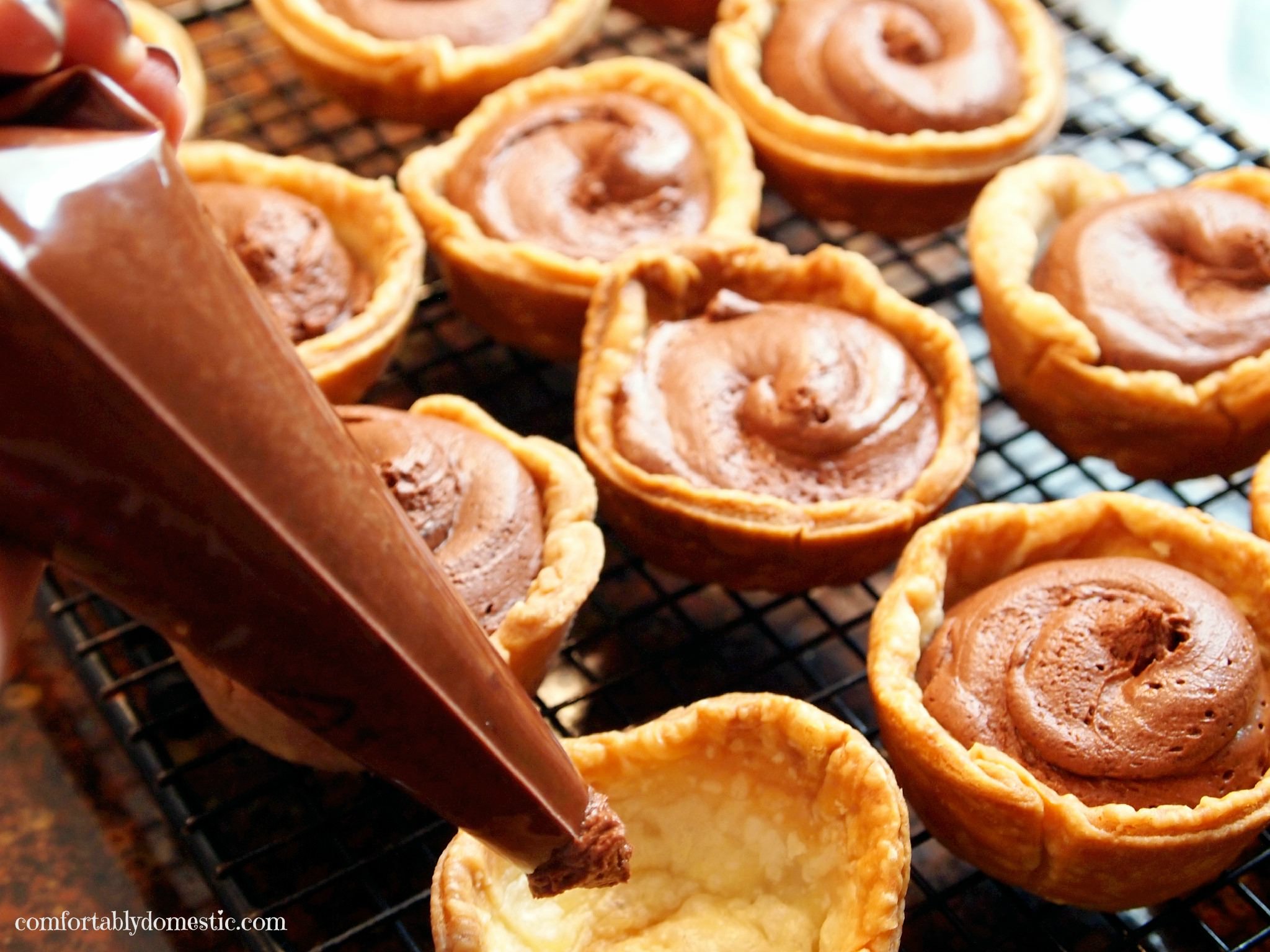 piping chocolate mousse into pie shells