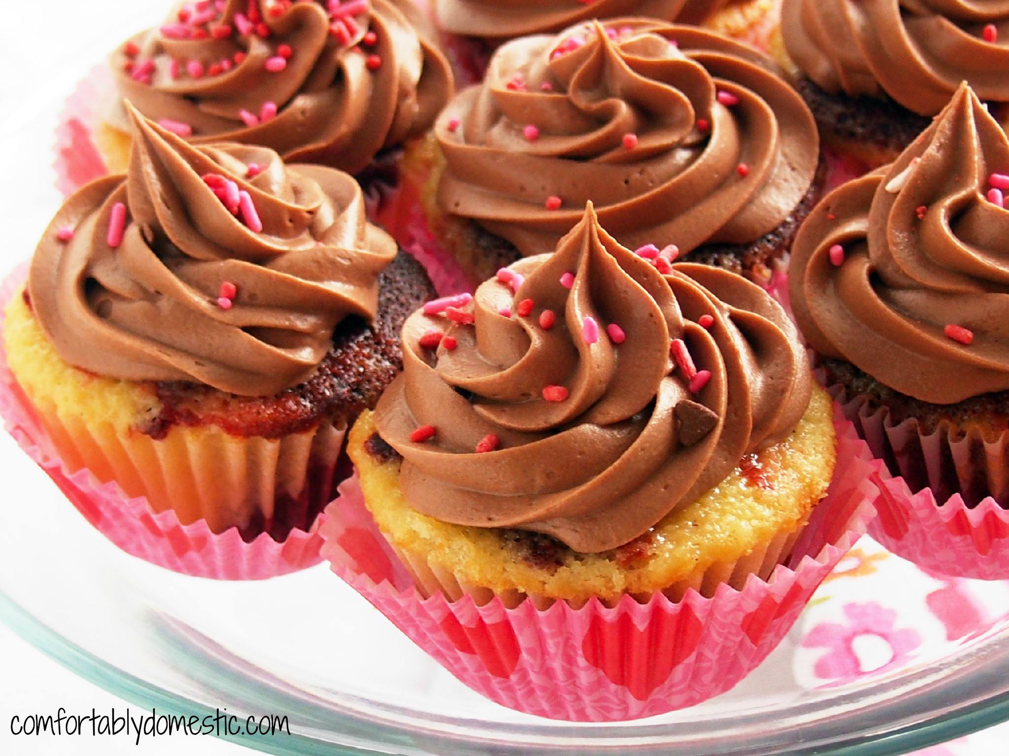 Red Velvet Vanilla Marble Cupcakes are a delicious combination of red velvet cake, marbled with moist vanilla cake. Topped with creamy, rich milk chocolate buttercream frosting. | ComfortablyDomestic.com