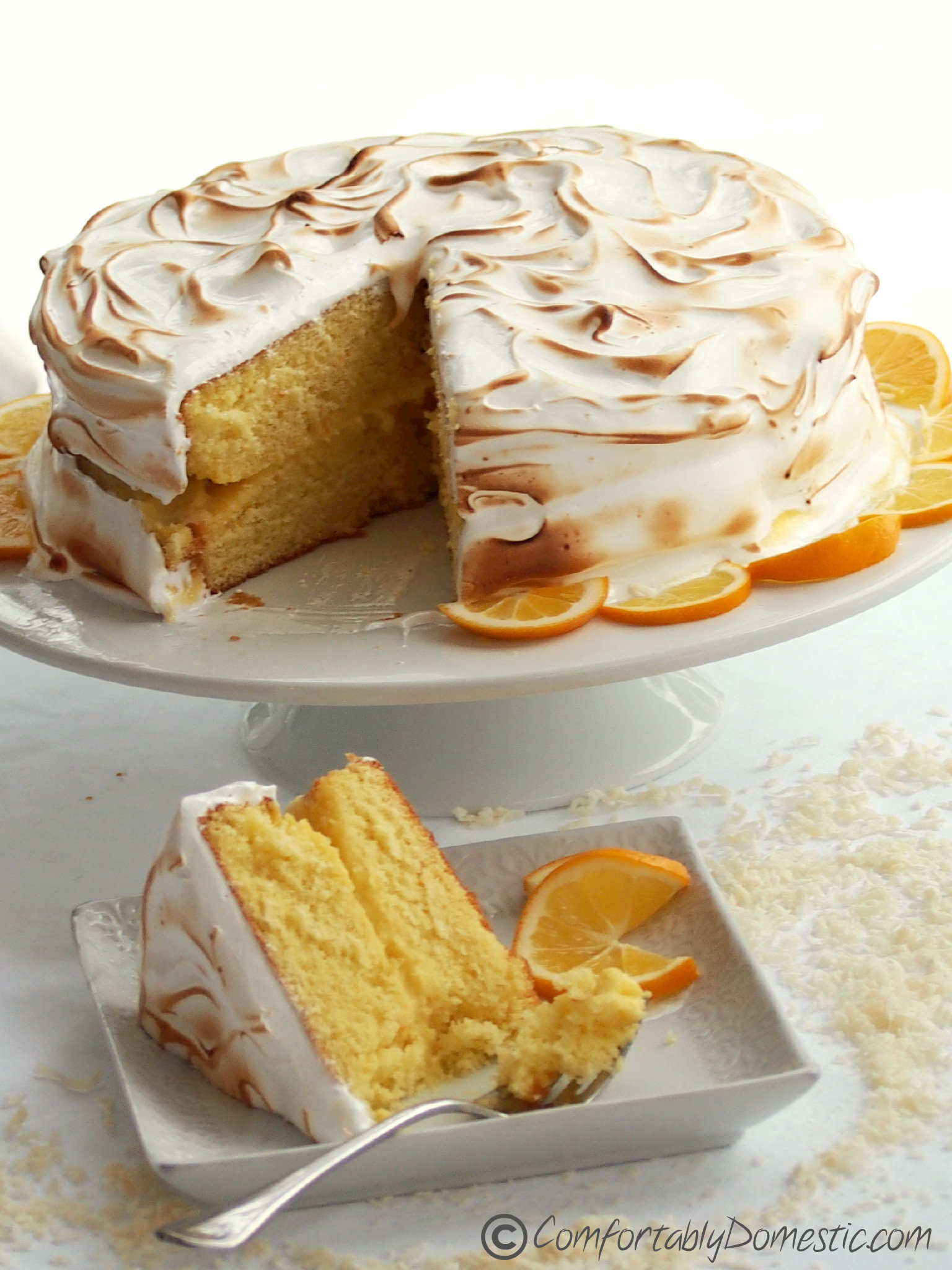 Coconut Meyer Lemon Meringue Cake - The balance of flavors and textures between moist cake, creamy lemon curd, and toasted Swiss meringue makes this Coconut Meyer Lemon Cake recipe a winner! | ComfortablyDomestic.com