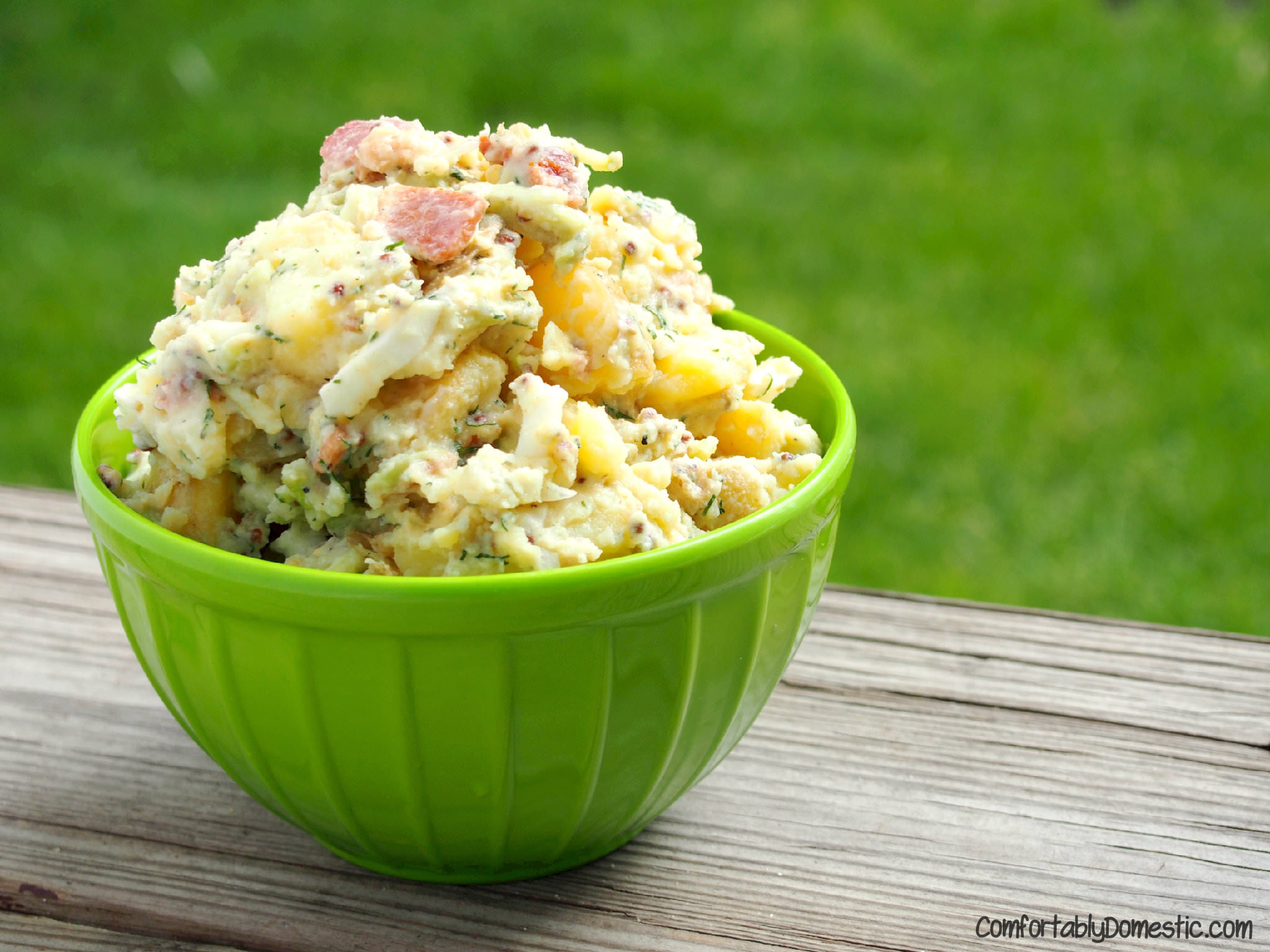 Creamy yellow potatoes are the base for dill potato salad, a lightened up version of classic potato salad, made with bacon, eggs, and plenty of fresh dill. | ComfortablyDomestic.com