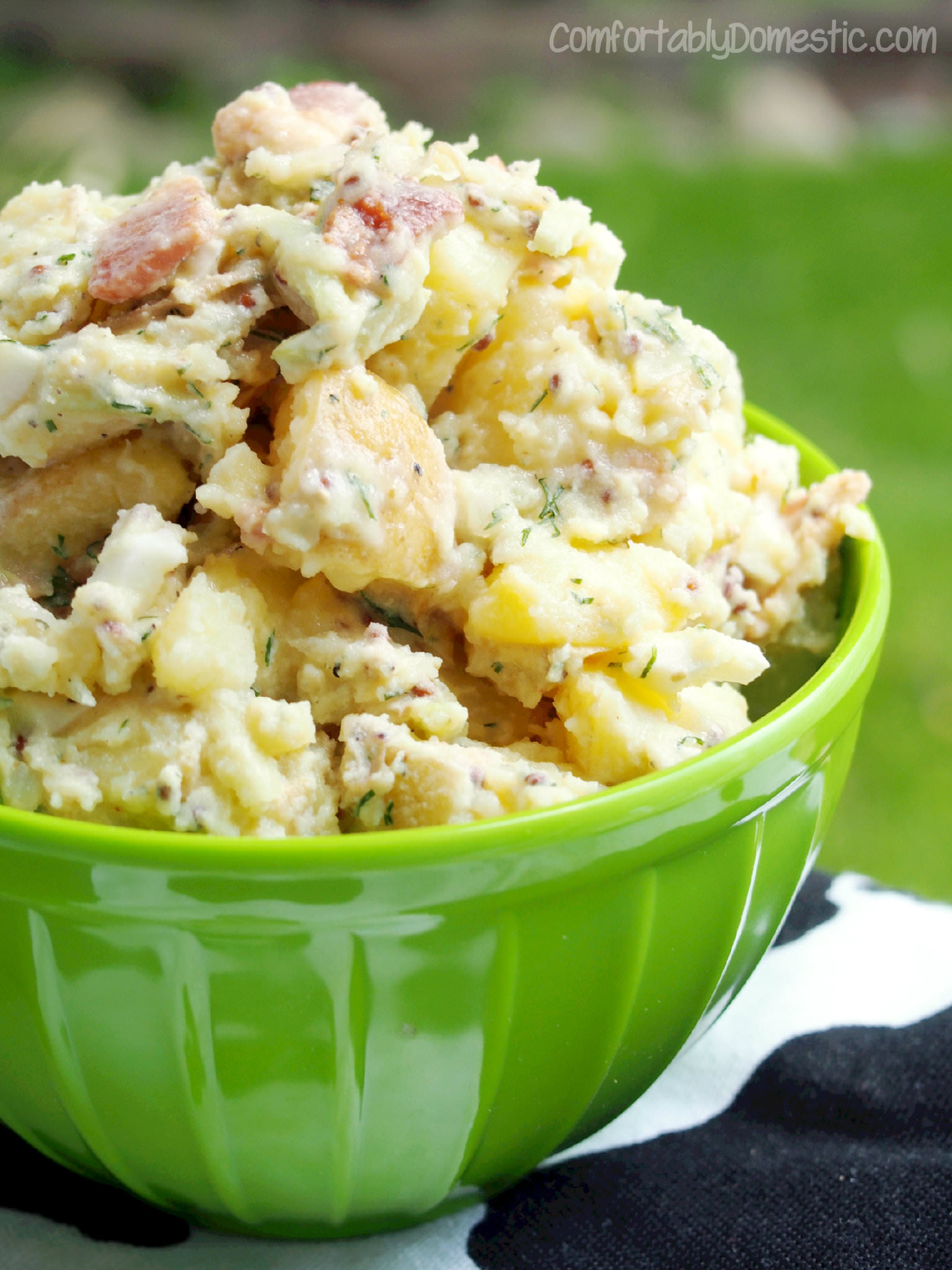 Creamy yellow potatoes are the base for dill potato salad, a lightened up version of classic potato salad, made with bacon, eggs, and plenty of fresh dill. | ComfortablyDomestic.com