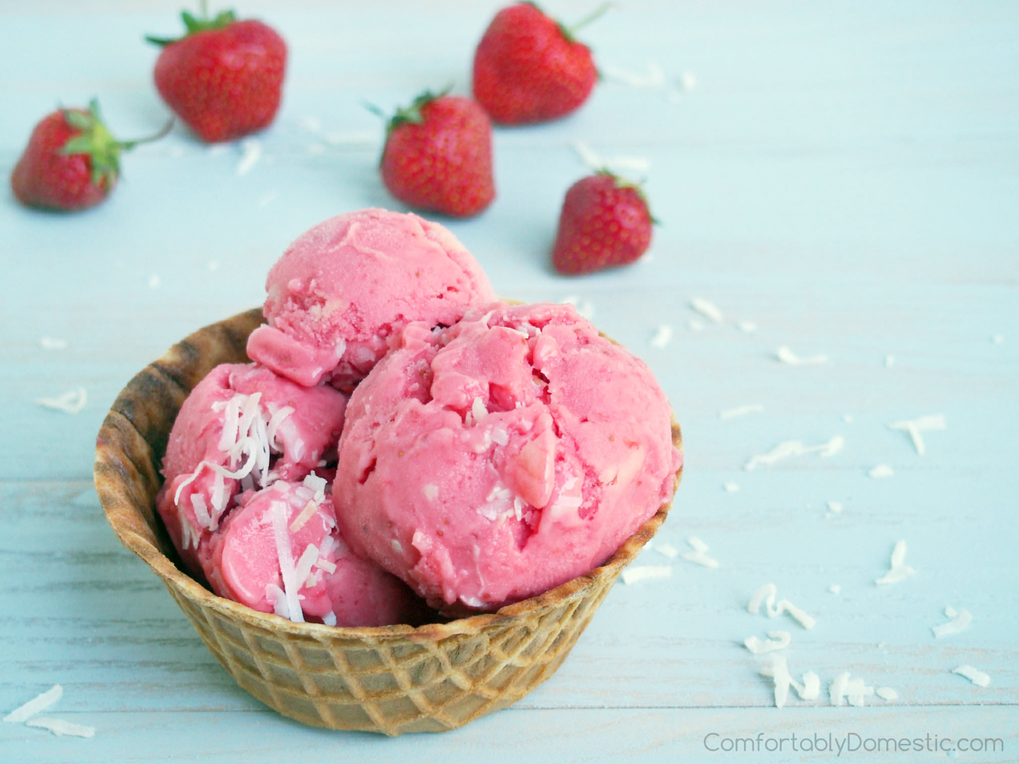 Strawberry colada frozen yogurt is a refreshing treat on a warm summer day. Ripe, juicy strawberries mingle with tangy pineapple and sweet coconut for a dreamy, creamy homemade frozen dessert. | ComfortablyDomestic.com