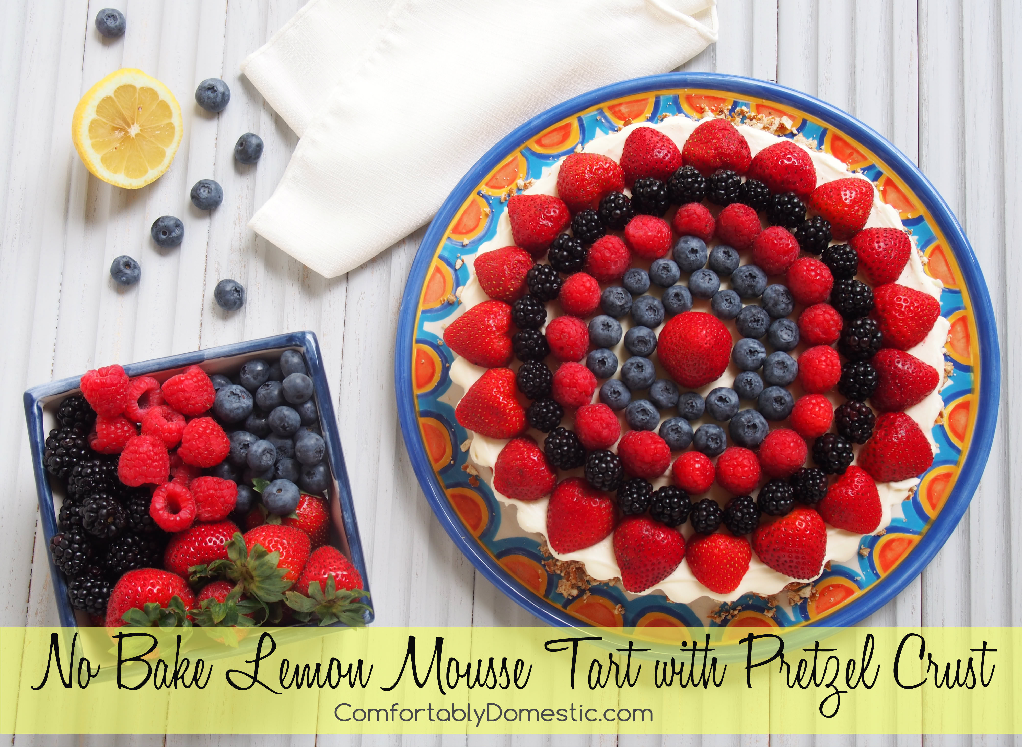 No bake lemon mousse tart is a delightfully bright dessert! Lemon mousse filling nestled in a pretzel crust, topped with fresh berries. The perfect balance of sweet, salty, creamy, and crunchy. | ComfortablyDomestic.com