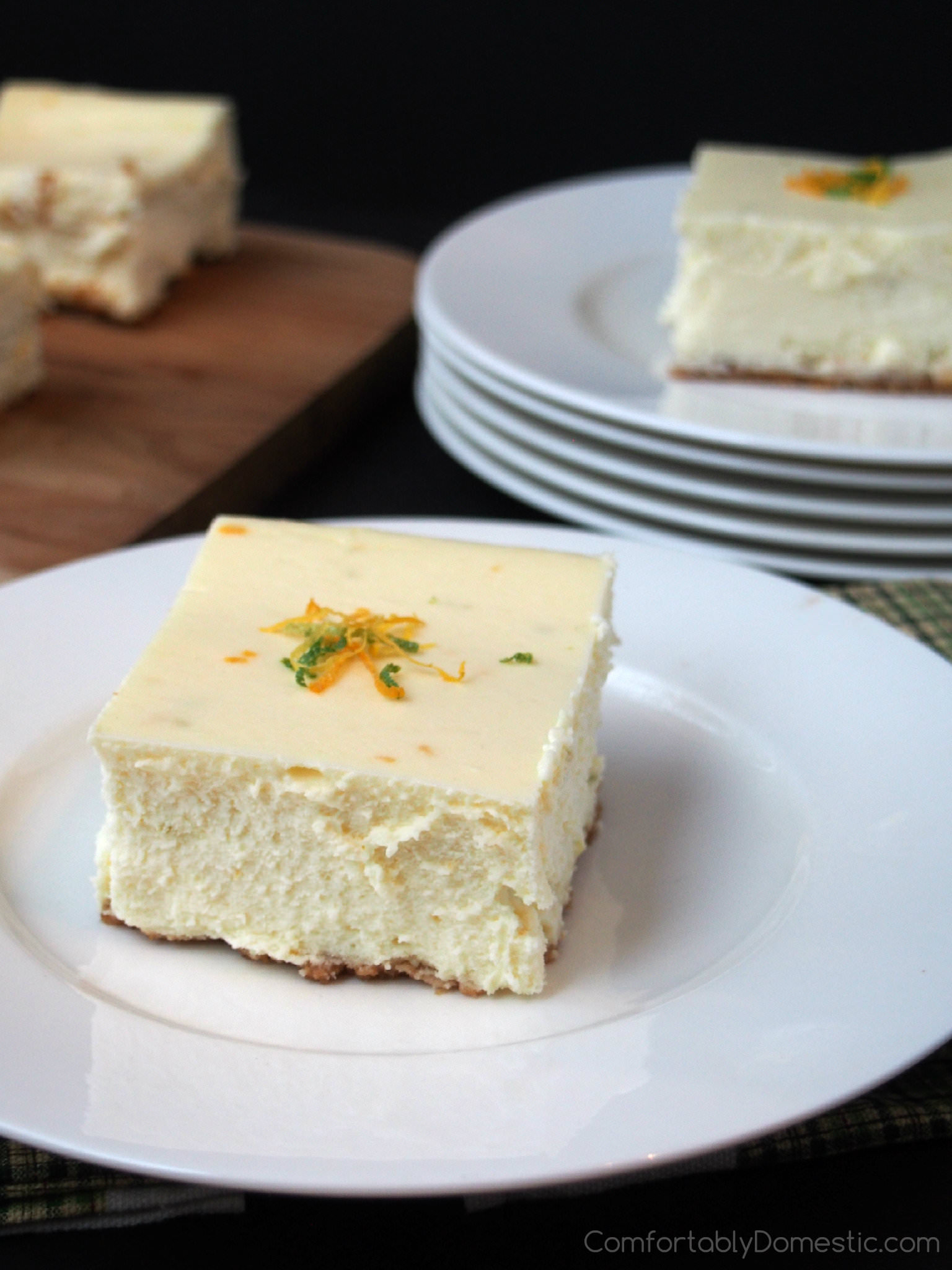 Triple Citrus Cheesecake - Classic New York style cheesecake infused with the tangy flavors of lemon, lime, and orange is made easy to share with a crowd. | ComfortablyDomestic.com